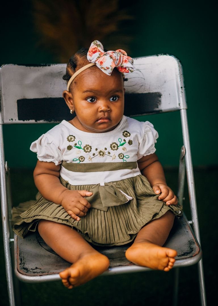 Baby girl wearing a soft fabric headband with a bow, an example of a gentle infant hairstyle