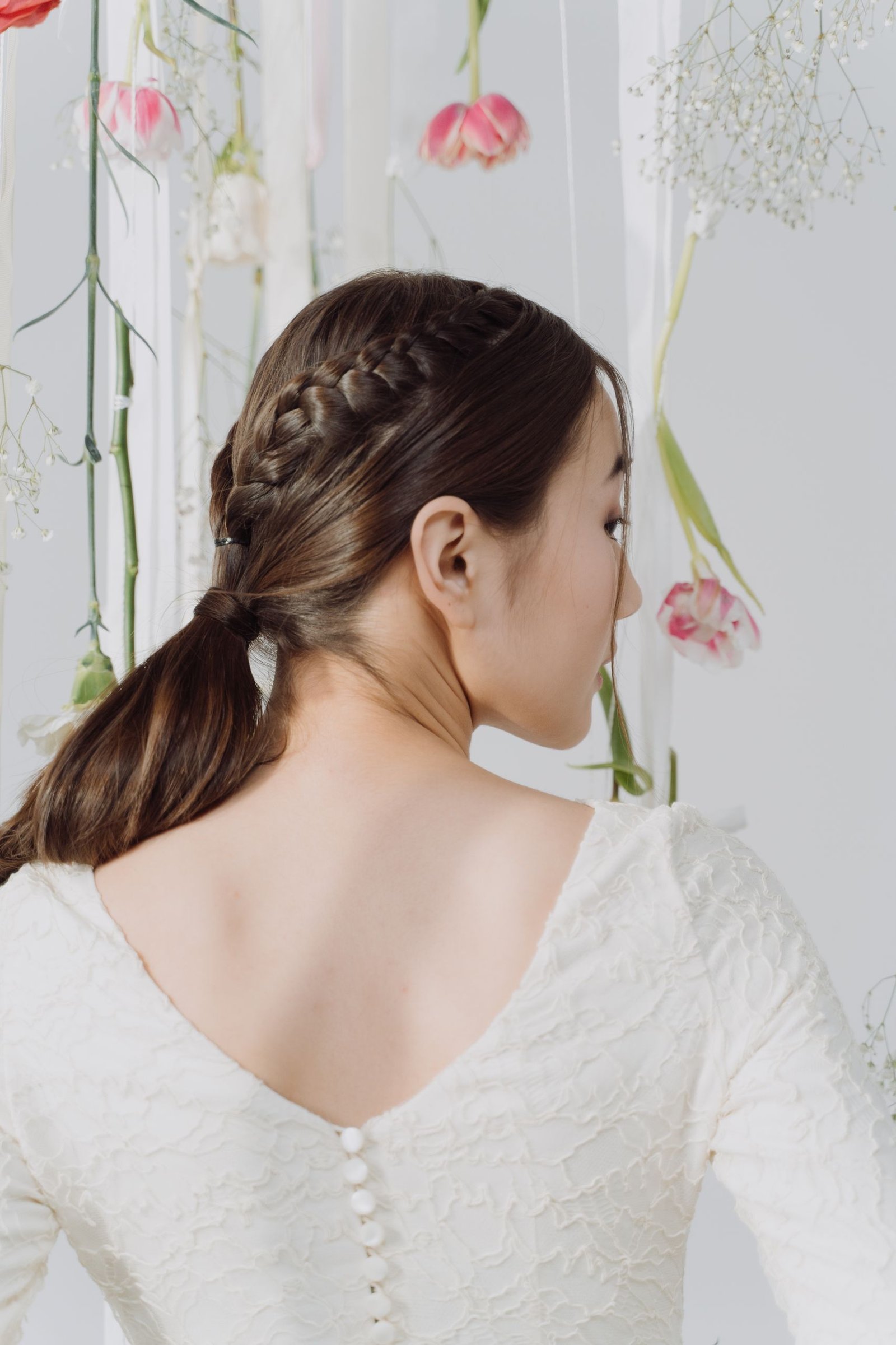 Back view of an Indian bride's braided hairstyle woven with flowers
