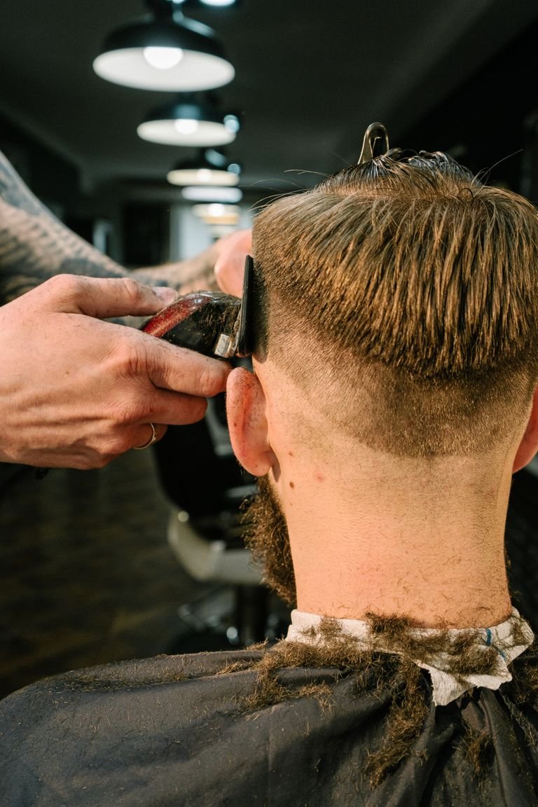 Barber giving a man a classic clean cut haircut in a modern barbershop