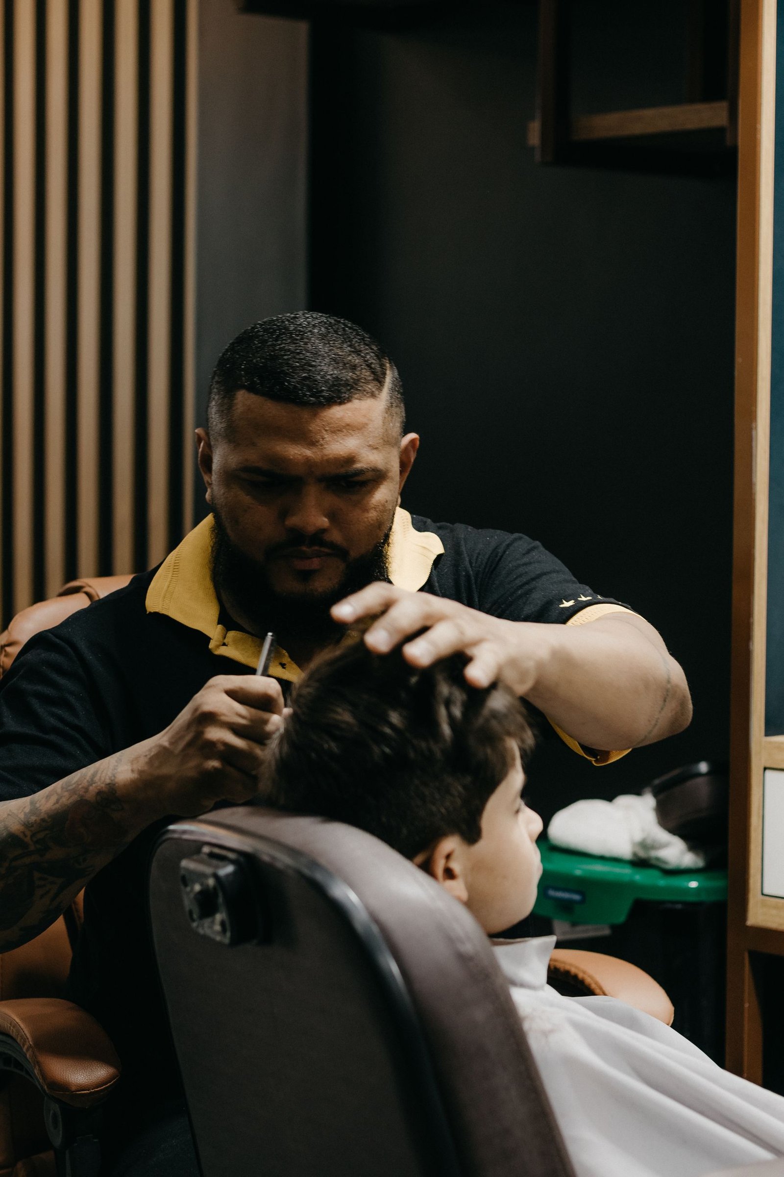 Barber giving a young boy a gentle scissor trim at a barbershop