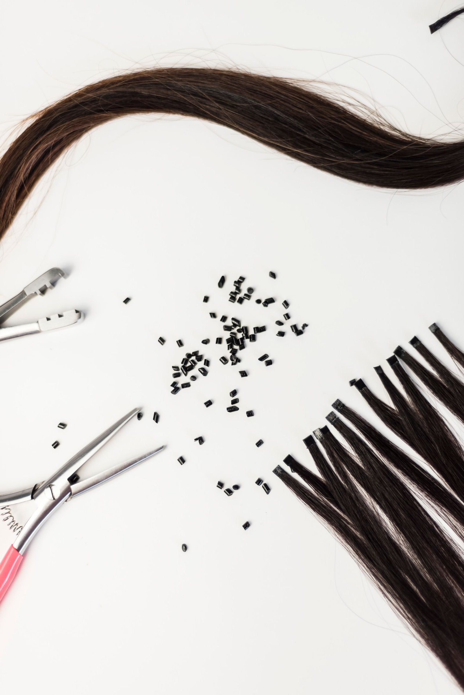 Close-up of a single hair extension weft with sectioning clips used during application