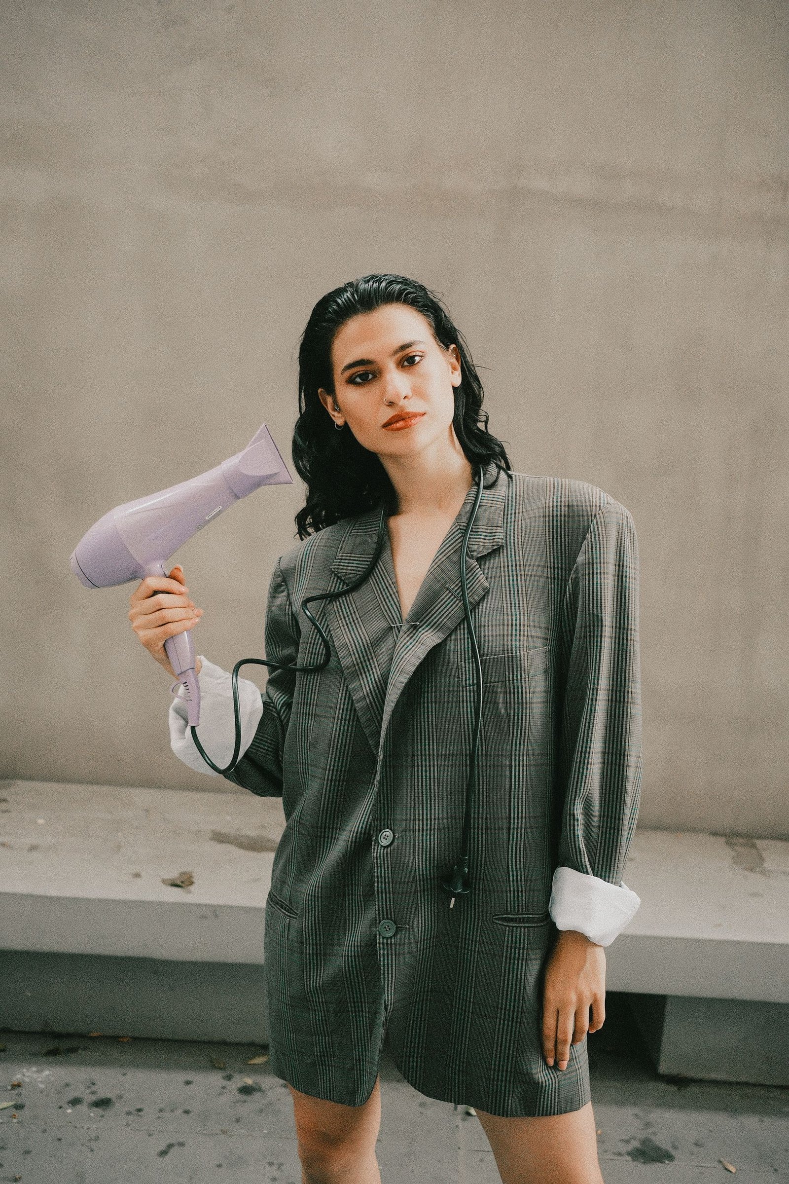 Woman styling retro-inspired 90s hair with a blow dryer
