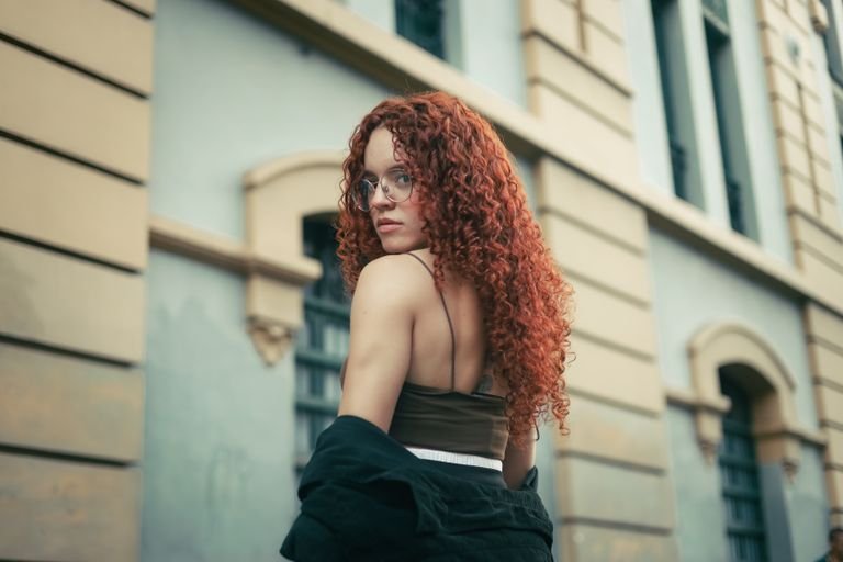 Woman with vibrant red colored curly hair styled naturally