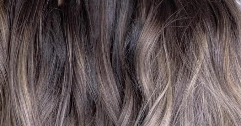 Blonde ombre hair transitioning from a dark brown root into lighter blonde ends
