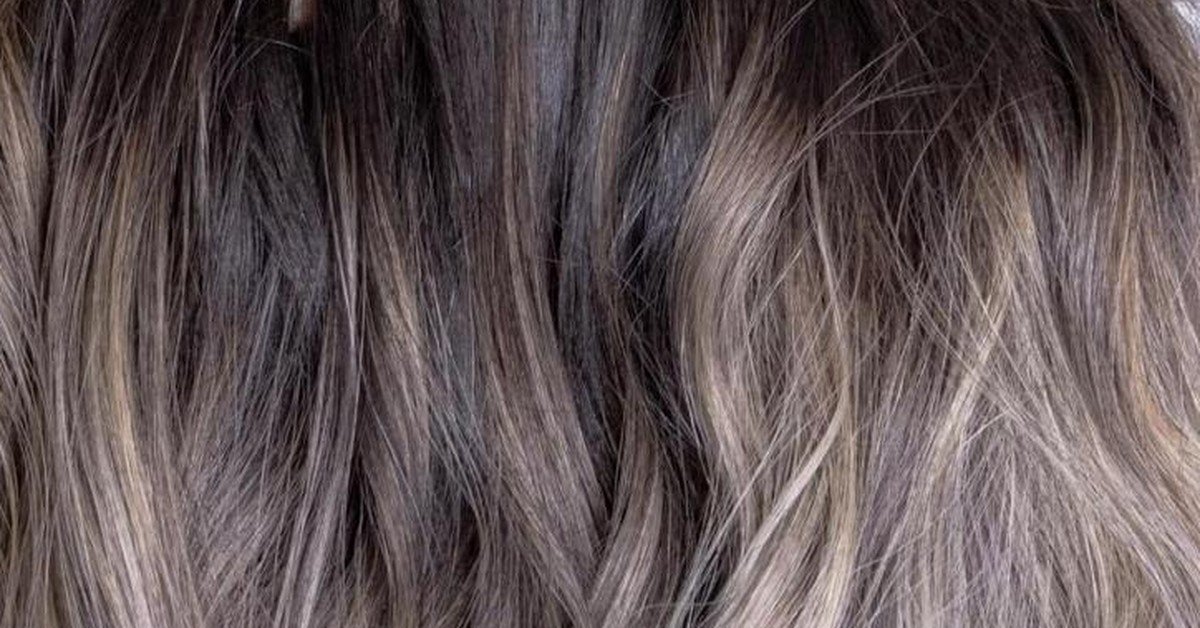 Blonde ombre hair transitioning from a dark brown root into lighter blonde ends