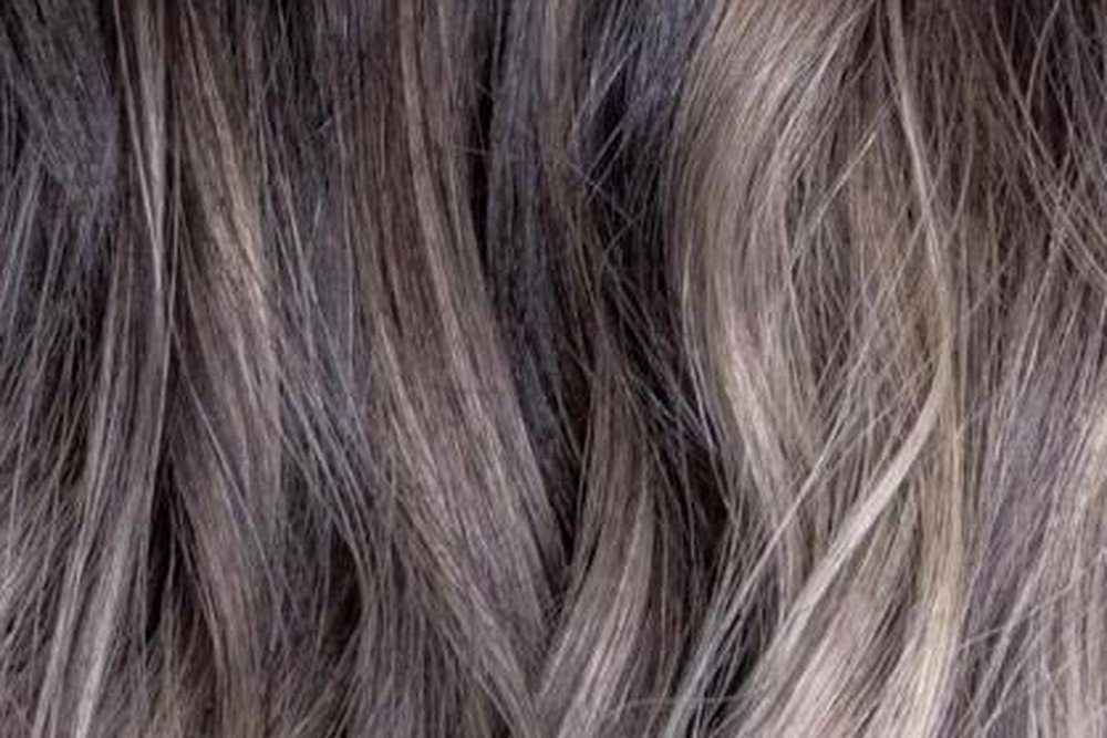 Close-up of wavy hair showing a blended dark-to-blonde ombre color transition