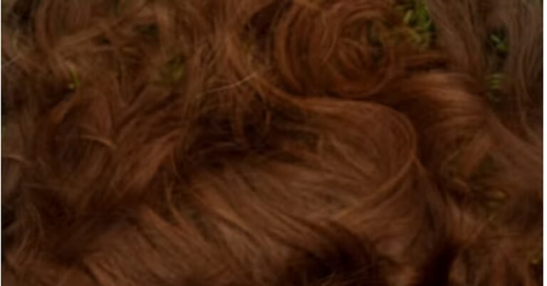 Rich reddish-brown wavy hair fanned out showing warm auburn dimension