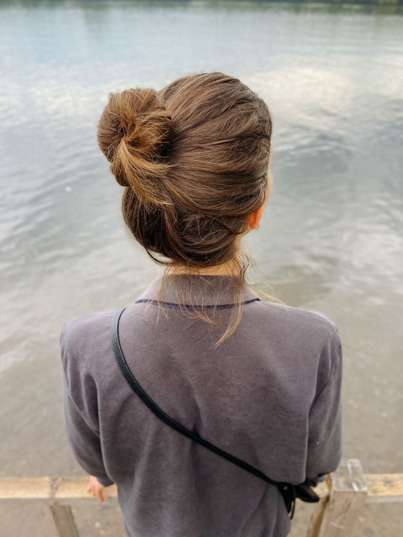 Woman wearing a bun hairstyle, back view outdoors
