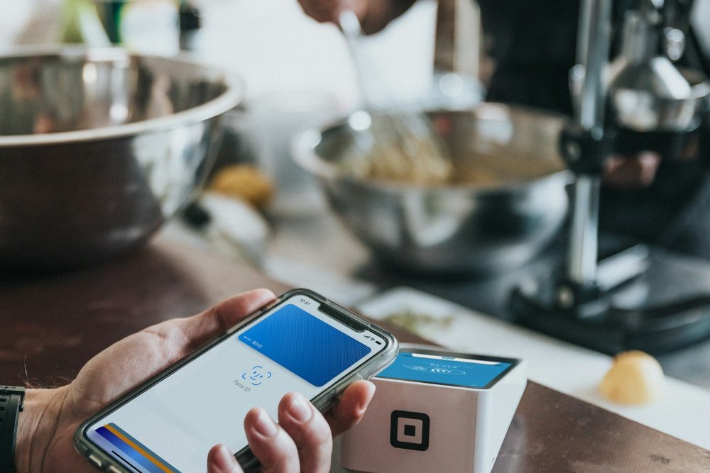 Hand paying a utility bill online using a smartphone and card