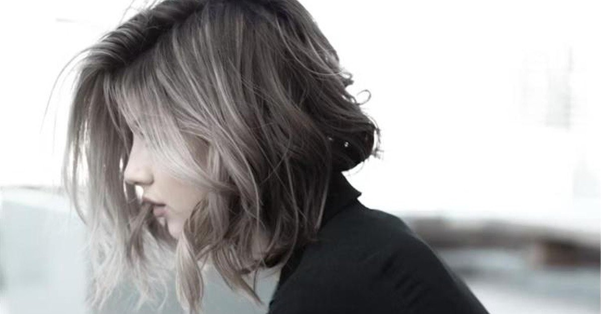 Layered gray and silver hair styled with soft waves and face-framing pieces