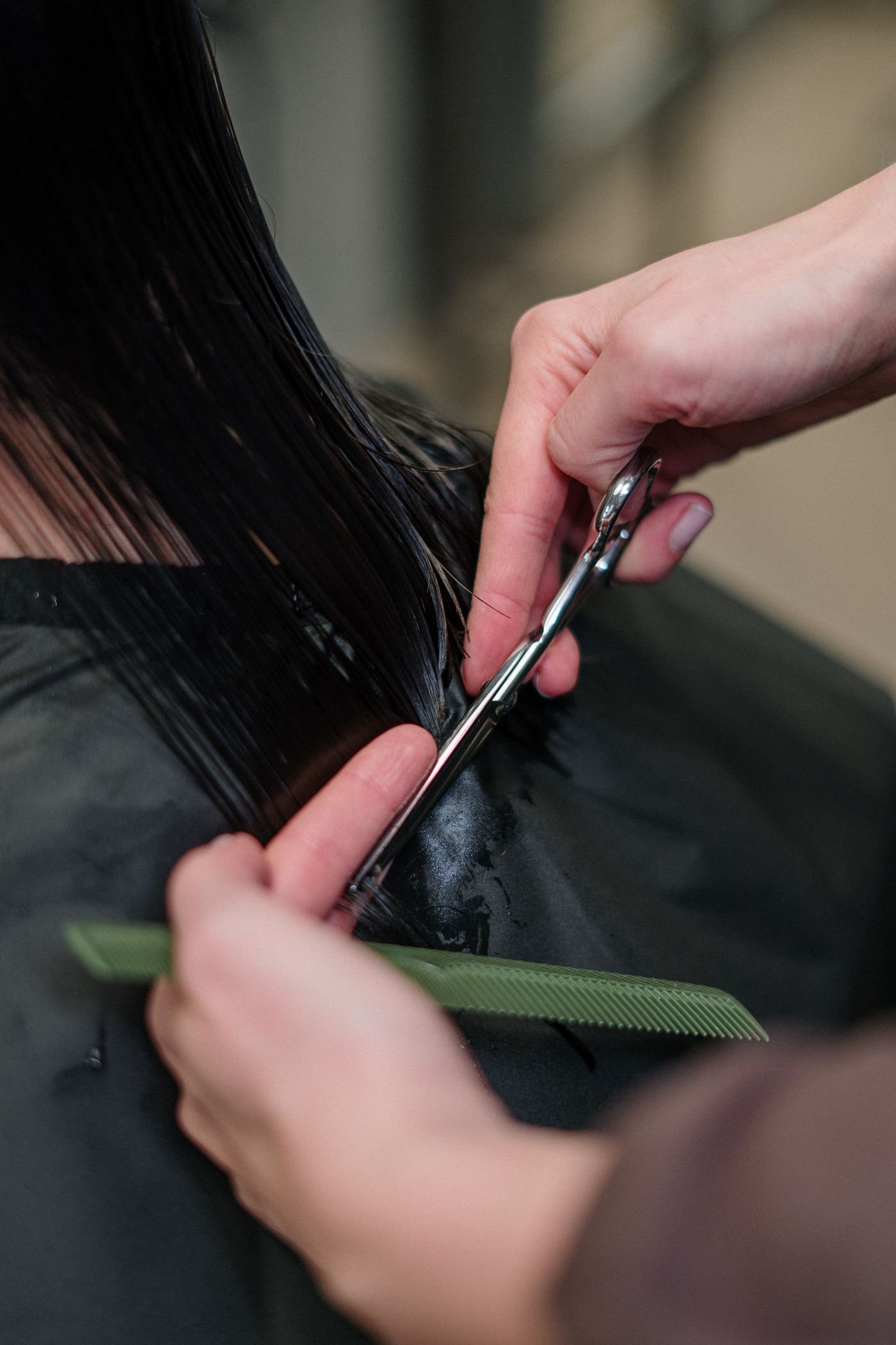 Hairdresser cutting hair in a salon, focusing on precision
