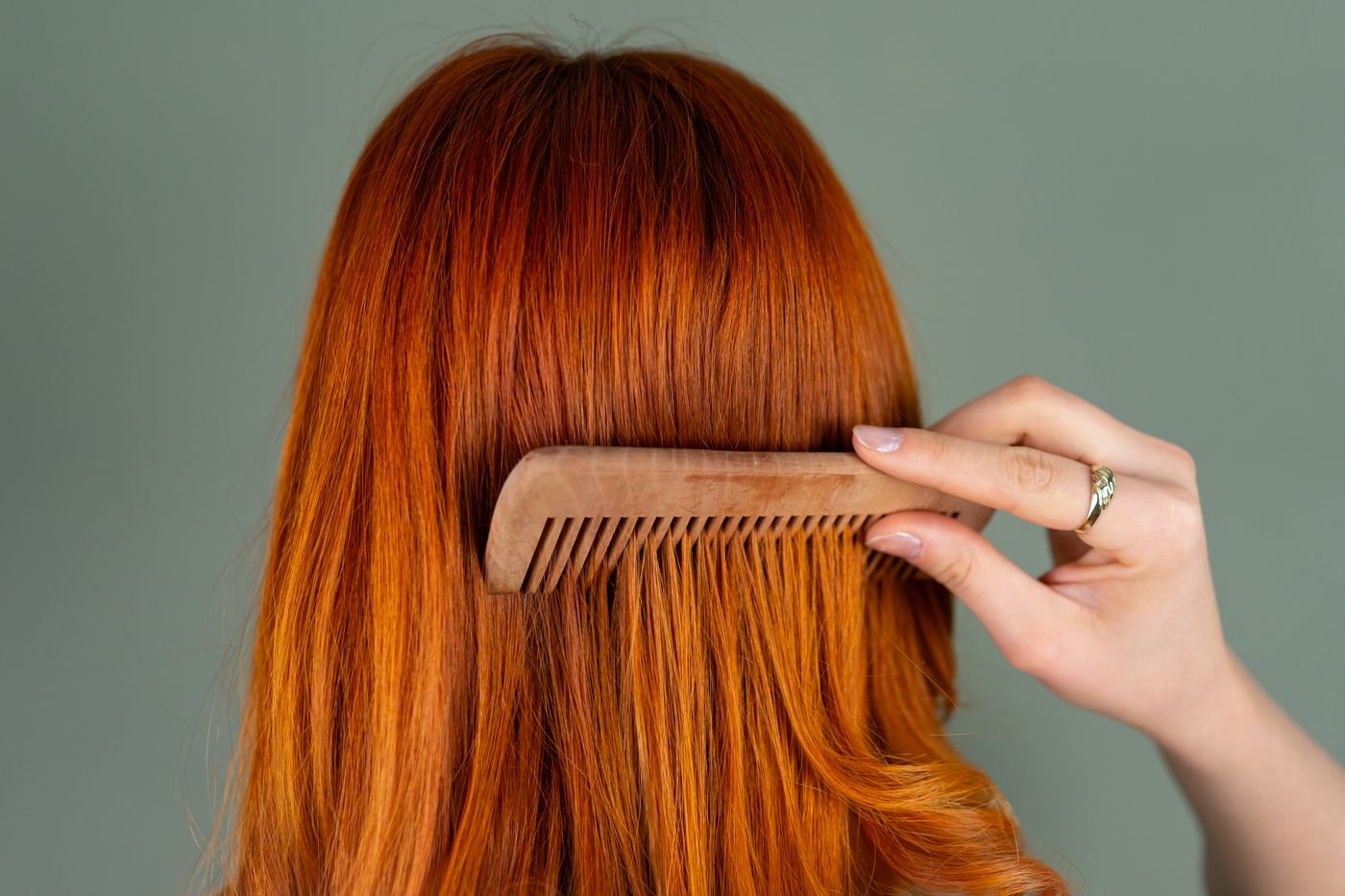 Close up of hair being combed with a wooden comb