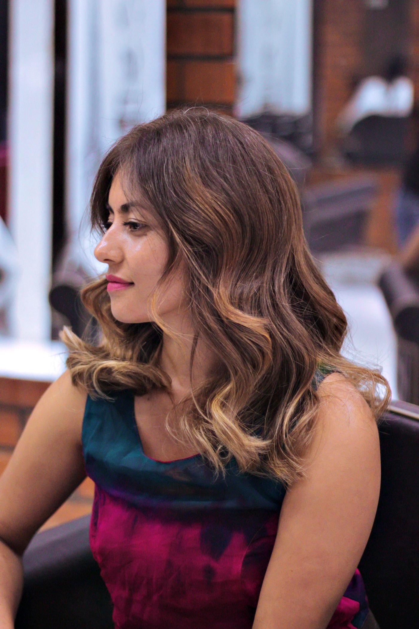 Woman with elegantly styled brown hair in a salon chair