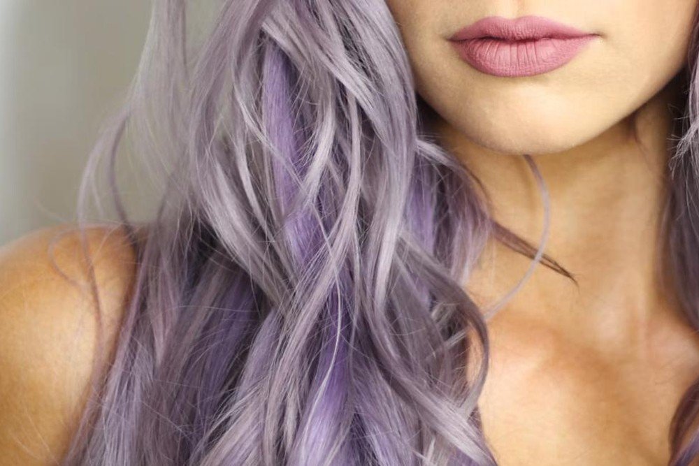 Close-up of long wavy hair in a dimensional red-violet shade showing lighter and darker plum tones